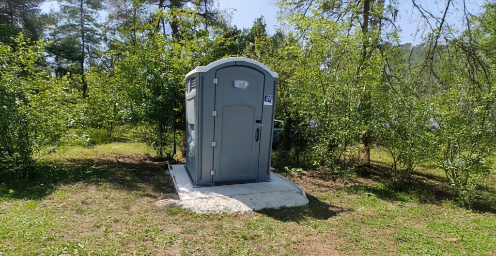 Bloc sanitaire autonome PMR installé dans un espace naturel dans le Jura