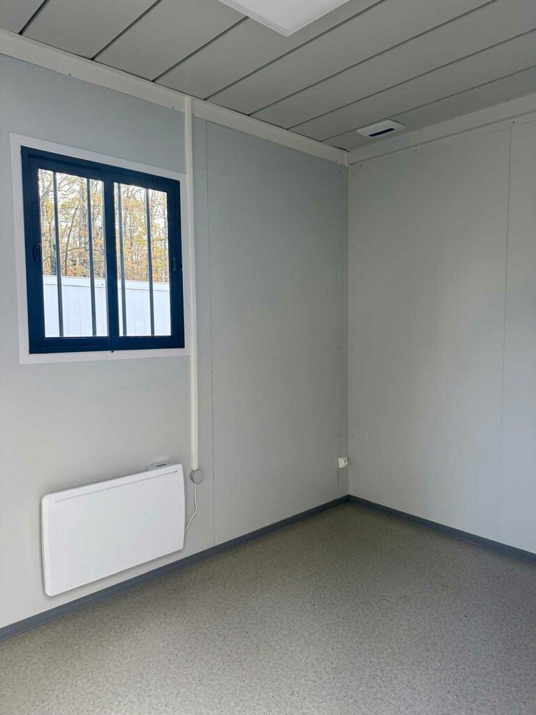 Intérieur d'un bungalow de chantier équipé d'un convecteur et d'un éclairage LED